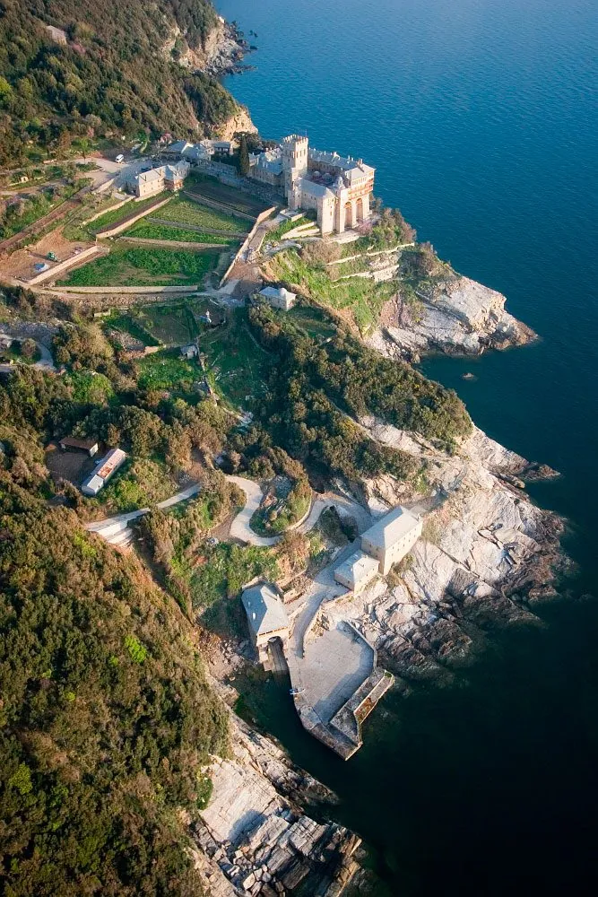 Aerial view of monastic gardens, forest, rock and sea on Mount Athos