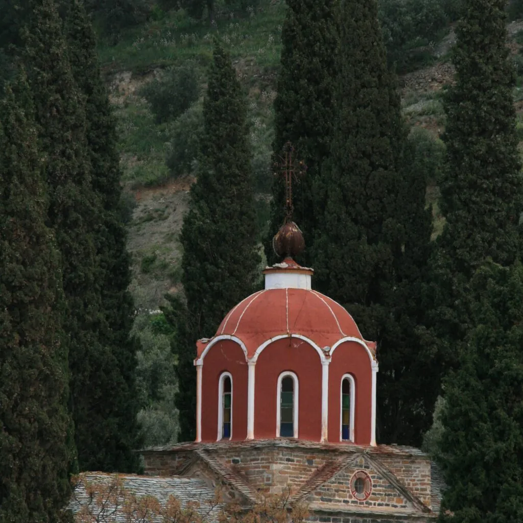 Red-domed chapel among the forested slopes of Mount Athos