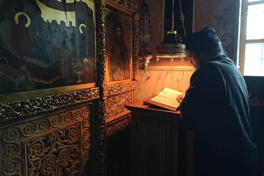 A monk praying before icons in a Mount Athos chapel
