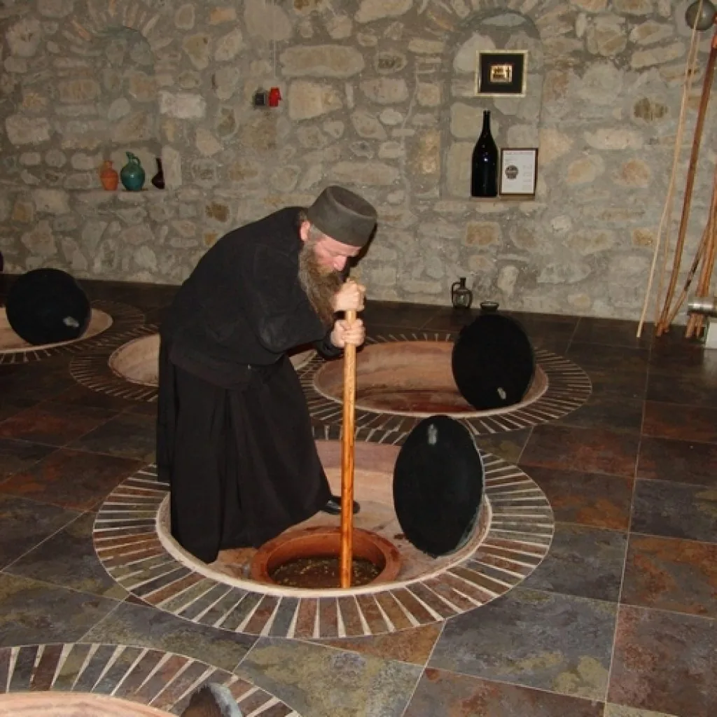 Monk working with grapes in a traditional winery